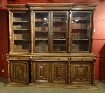 un vaisselier en bois avec des portes en verre dans une pièce