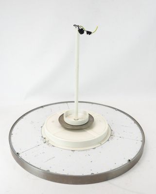 une horloge blanche surmontée d'un oiseau noir