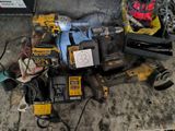 a pile of power tools on the floor in the garage