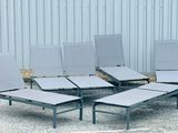 four lounge chairs that are sitting in the gravel