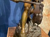 bronze statue of a man with a spear and shield on a wooden base