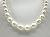 a close up of a white pearl necklace on a mannequin