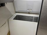 an open refrigerator in the corner of a small kitchen