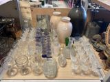 many glasses and vases on a table in a store
