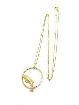 Gros plan sur un collier en or orné d'un oiseau