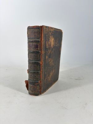 an old book sitting on top of a table next to a white wall