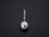 une image représentant un pendentif composé d'une perle noire et de diamants, sur fond noir