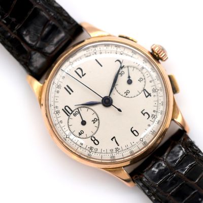 a close up of a watch on a white surface