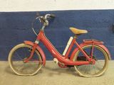 un vélo rouge garé contre un mur bleu