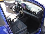 the interior of a blue car with the door open and the driver ' s seat up