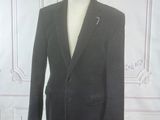 a suit on a mannequin stand in front of a white wall