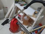 a picture of a cluttered bathroom with a vacuum and a toilet