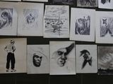 a lot of drawings hanging on the wall of a room