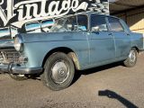 une vieille voiture bleue garée devant un immeuble