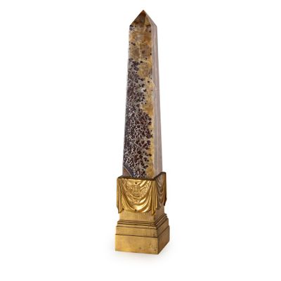 sculpture représentant un obélisque sur un socle à base dorée