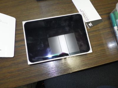 une tablette posée sur un bureau en bois