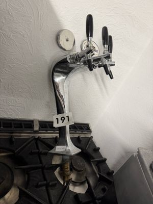 un robinet à bière posé sur une cuisinière à gaz dans une cuisine