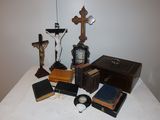 a small table with a clock, books, and a crucifix on it