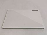 a white laptop computer sitting on top of a bed
