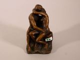 une figurine représentant un homme et une femme assis sur un rocher
