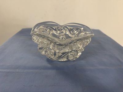 un saladier en verre transparent posé sur un napperon bleu