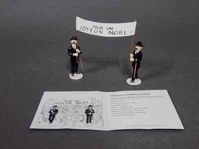deux figurines représentant deux hommes tenant une pancarte