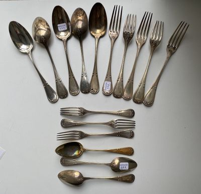 many spoons and forks laid out on a table