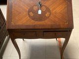 a small wooden desk with a clock on top of it