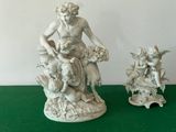 two figurines of a woman and a child on a green table