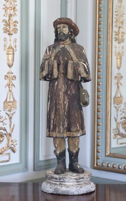 une statue représentant un homme debout devant un miroir
