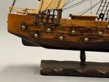 une maquette en bois d'un voilier posée sur un socle