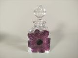 a glass bottle with a purple flower inside of it