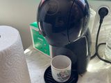 a coffee maker sitting on a counter next to a roll of toilet paper