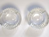 pair of clear glass ashtrays on a white surface