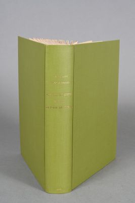 an open book with a green cover sitting on top of a table