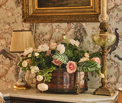 un vase de fleurs posé sur une table à côté d'une lampe