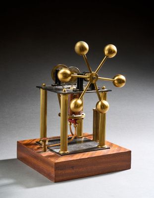 une image représentant une maquette d'horloge posée sur un socle en bois