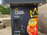un distributeur automatique de pizzas surmonté d'une couronne