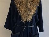 black coat with fur collar and belt on mannequin stand