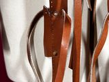 a white bag with brown straps on a mannequin