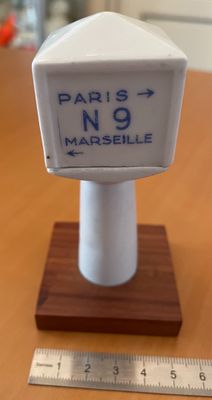 un panneau blanc et bleu posé sur un socle en bois