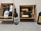 two bottles of wine are in a wooden box next to a bottle of wine