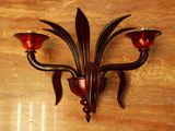 a wall sconce with three candles on it on the wall