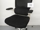 une photo d'une chaise de bureau noire sur laquelle est apposée une étiquette de prix