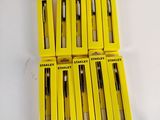 six yellow boxes of pens sitting on top of a white table
