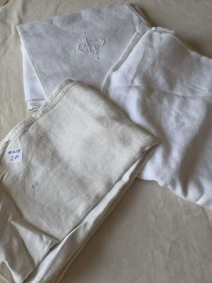 three pairs of pants laying on a bed next to each other