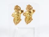 paire de boucles d'oreilles dorées ornées d'un visage de femme