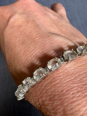 someone is wearing a bracelet with a lot of diamonds on it