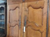 a large wooden cabinet with a glass door on top of it