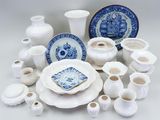 a lot of white and blue dishes and vases on the table